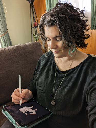 Ilana Leah LLC Small Business Design and Marketing Consulting; a white woman with brown curly hair looking down at a tablet she is drawing on.